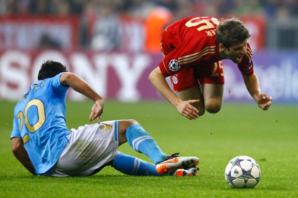 Играчът на Наполи Блерим Джемали (в син екип) току-що е фаулирал грубо Томас Мюлер от Байер Мюнхен по време на мача между двата отбора от Шампионската лига. "Баварците" победиха с 3:2 на своя "Алиац Арена" и са убедително начело в група A. Снимка: Reuters