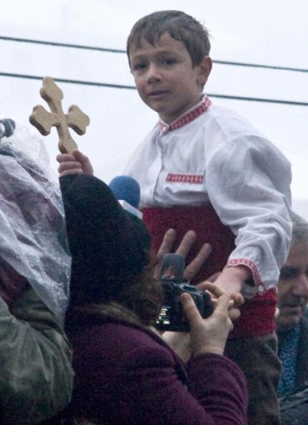 Малкият Иван Диклиев държи Богоявленския кръст в Калофер. Малкото момче бе най-младият участник в традиционното мъжко хоро в града. Снимка:  Булфото