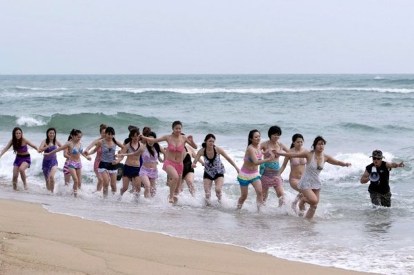 Спасител тренира момичета за спасителки в курорта Саня, провинция Хайнан. Групата от 20 спасителки скоро ще завършат 10 месечен курс по плуване и оказване на първа помощ на пострадали летовници. Снимка: Reuters