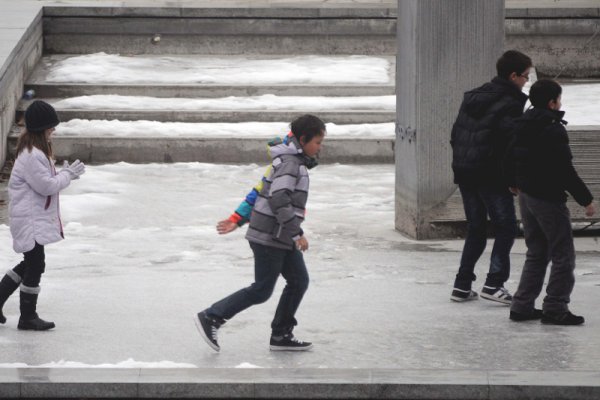 Деца се пързалят по заледеното дъно на фонтан в центъра на Пловдив. Снимка: БТА