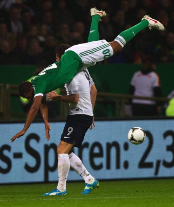 Германският национал Джером Боатенг (в зелен екип) пада след борба за топката с французина Оливие Жиру по време на контролата между двата тима в Бремен. Германия, която е сочена сред големите фаворити за Евро 2012, загуби изненадващо с 1:2. Снимка: БТА