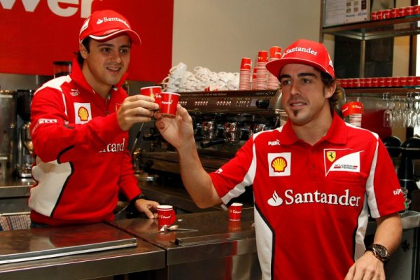 Пилотите на Ферари Фелипе Маса (в ляво) и Фернандо Алонсо вдигат наздравица с кафе по време на медийно събитие на &bdquo;скудерията&ldquo; в Мелбърн. Снимка: Reuters