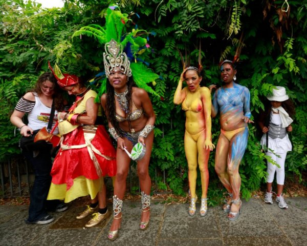 Участници в карнавала "Нотинг хил" в Лондон се крият от дъжда. Снимка: Reuters