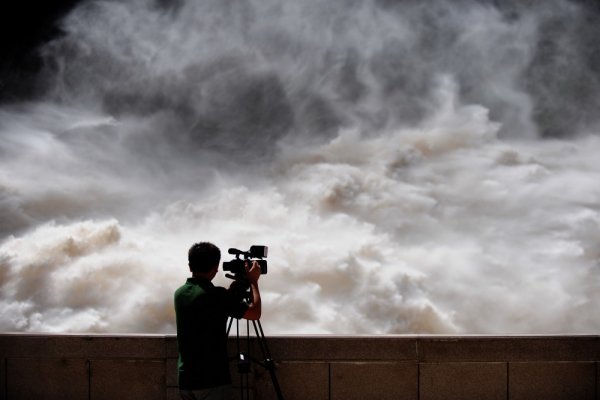 Оператор снима прииждащата вода при наводненията в китайската провинция Гансу. Снимка: БТА