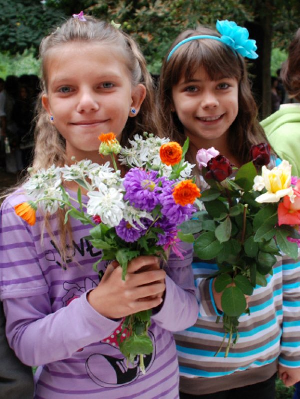 Момиченца първокласннички от ОУ "Васил Априлов" в Исперих позират с цветя преди първия училищен звънец. Снимка: БТА
