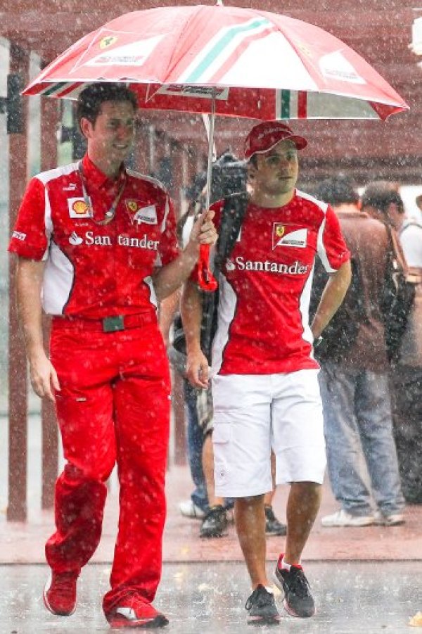 Бразилският пилот на Ферари Фелипе маса се разхожда в дъжда на пистата „Марина Бей“. В неделя там ще се проведе Гран При на Сингапур. Снимка: БТА
