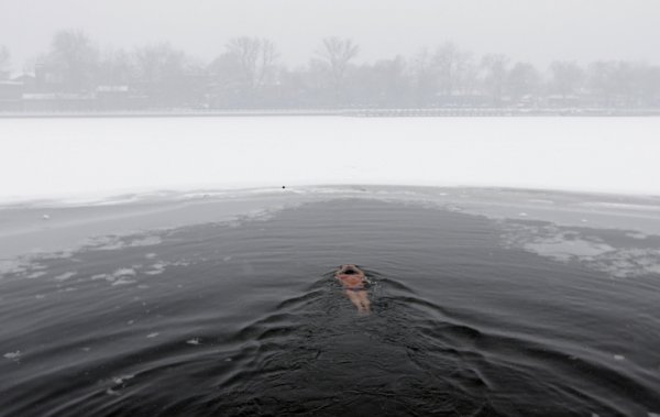 Мъж плува в ледените води на езерото Хоухай в центъра на Пекин, Китай. Снимка: Reuters