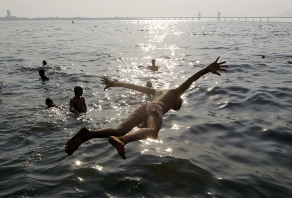 Индийско момче скача в морето в Мумбай. Снимка: БТА