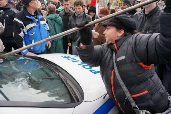 Протестираща във Варна мете символично полицейска патрулка. Снимка: Булфото