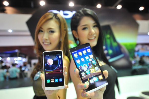 Тайландски манекенки представят мобилни телефони по време технологично изложение в столицата Банкок. Снимка: БТА