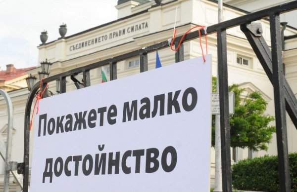 Металните заграждения около НС са окичени с надписи. На някои от тях пише: "Ако хирургът сгреши, леталният край е гарантиран", "Ще опазим парламента от лумпени и журналисти с всички средства"... Снимка: Булфото