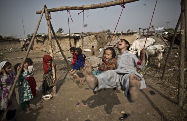 Афганистански деца, които са бежанци в Пакистан, се забавляват на люлка в беден квартал в покрайнините на столицата Исламабад. Снимка: БТА