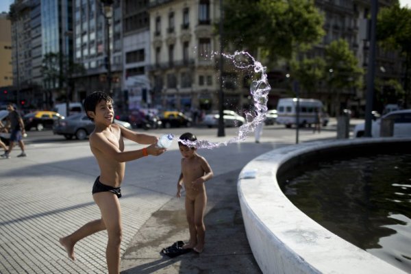 Докато студът е сковал Европа, в Южното полукълбо е лято. 12-годишният Роберто и малкият му брат Алехандро се разхлаждат край шадраван в Буенос Айрес, Аржентина. Снимка: БТА