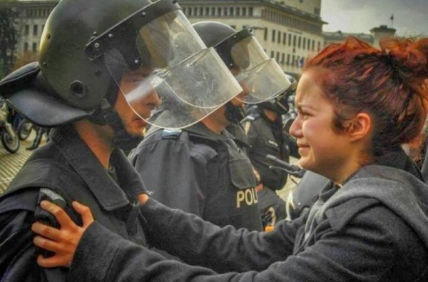 Във времето остана и една емблематична снимка на отминаващата 2013 г.&ndash; полицаят и плачещата протестираща. Снимка: Facebook