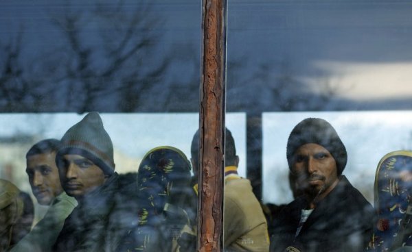 Пристигащи бежанци гледат от автобуса лагера в Харманли. Снимка: Reuters