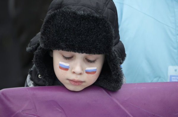 Малко момче напразно очаква старта на дисциплината сноубордкрос при мъжете от игрите в Сочи. Заради лошото време и мъглата състезанието бе отменено за утре. Снимка: БТА