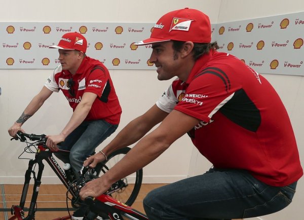 Пилотите на Ферари Кими Райконен (в ляво) и Фернандо Алонсо карат велосипеди по време на събитие в Австралия преди старта на Сезон 2014 във Формула 1. Първото състезание за сезона е в неделя на пистата Албърт Парк край Мелбърн. Снимка: БТА