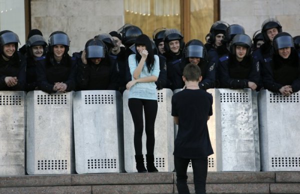 Донецк, Украйна. Младеж снима гаджето си на фона на украински полицаи за борба с безредиците. Снимка: Reuters