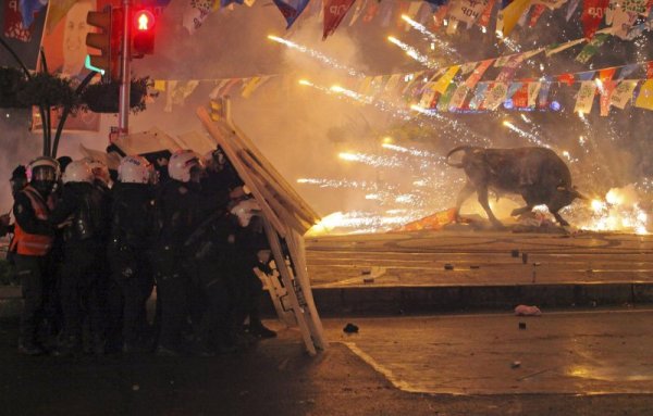 Полицаи се крият от фойерверки, хвърлени от протестиращите по време на антиправителствен протест в квартал Кадъкьой в Истанбул. Снимка: Reuters