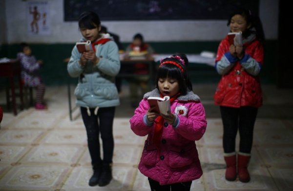 Ученици четат настолната &quot;Малка червена книга&quot; на Мао Цзедун. Снимка: Reuters