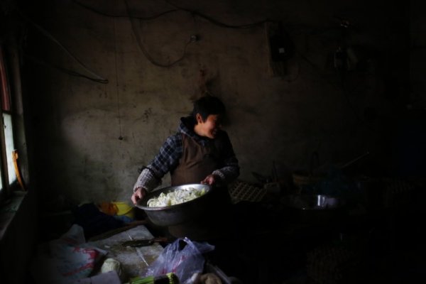 Уанг Хуи подготвя храна за учениците. Снимка: Reuters