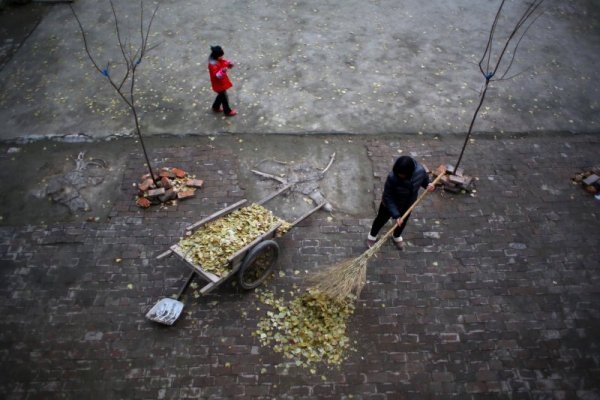Жена почиства двора от нападалите листа. Снимка: Reuters