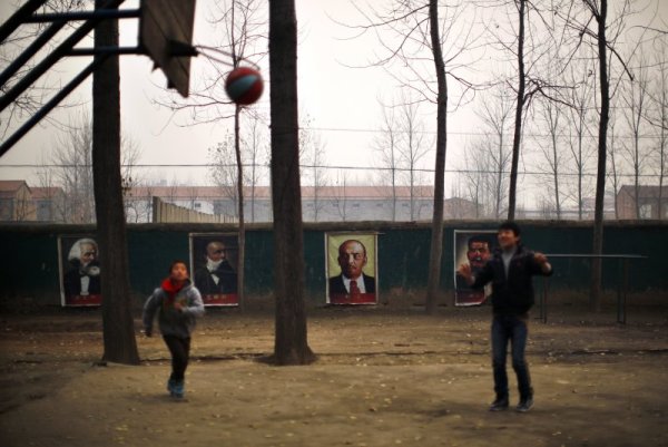 Ученици играят баскетбол, на игрището са подредени портрети на Карл Маркс, Фридрих Енгелс, Ленин и Сталин. Снимка: Reuters