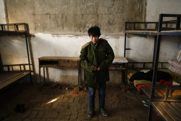 Момче се преоблича като войник за церемонията, на която се издига флагът на комунистическата държава. Снимка: Reuters