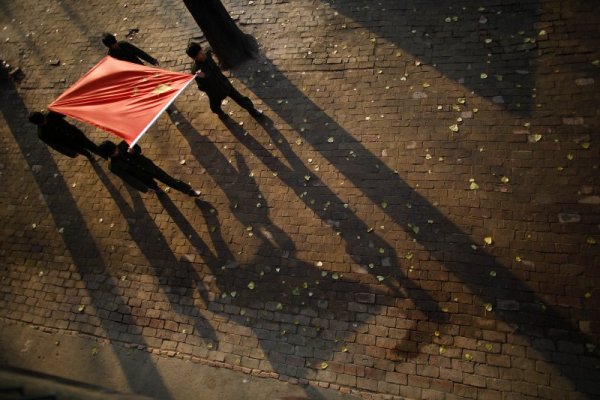 Ученици носят китайския флаг на церемония. Снимка: Reuters