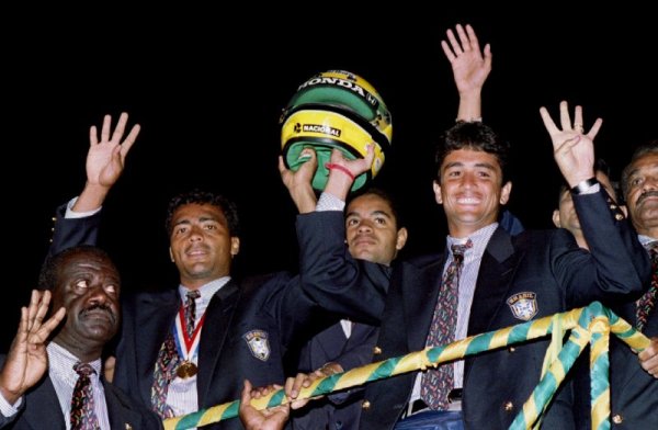 Звездите на "селесао Ромарио и Бебето носят каската на Аертон Сена по време на празненствата за спечелването на световното първенство по улиците на столицата Бразилия. Снимка: Reuters