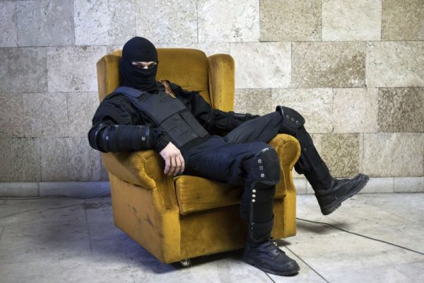 Маскиран проруски сепаратист си почива на фотьойл в коридор на административна сграда в украинския град Донецк. Снимка: Reuters