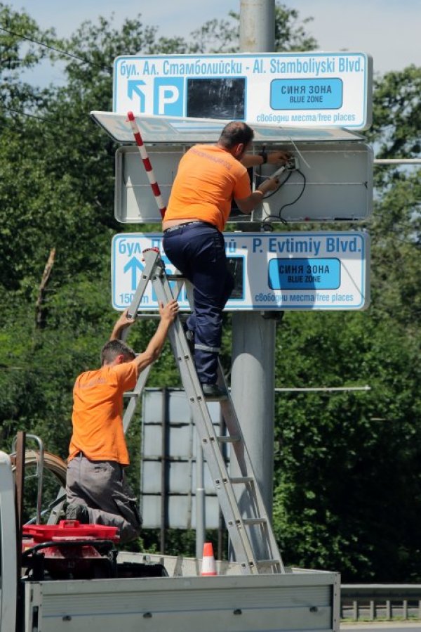 Работници монтират електронни табла, които ще показват колко свободни места има на паркингите &quot;Синя зона&quot; в столицата. Снимка: БТА