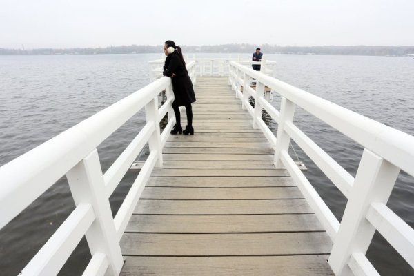 Млада жена съзерцава водата на мост край езерото Ванзее край Берлин. Топлите за средата на ноември дни изкараха много германци в близост до природата. Снимка: БТА