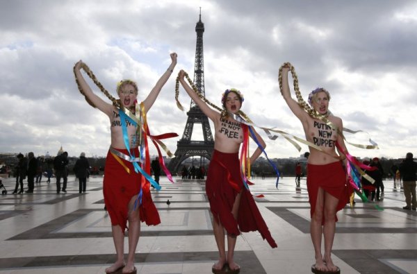 Активистки на ФЕМЕН протестират пред Айфеловата кула в Париж срещу украинския опозиционен лидер Юлия Тимошенко. Те изписаха на телата си "Юнукович = Тимошенко&ldquo;, "Украйна не е свободна&ldquo; и "Новата кукла на Путин&ldquo;. Снимка: Reuters