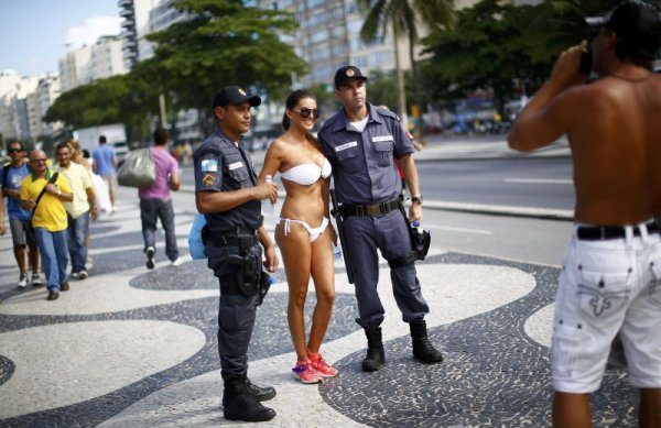Млада жена по бански се снима за спомен с бразилски полицаи в центъра на Рио де Жанейро. Снимка: Reuters
&nbsp;