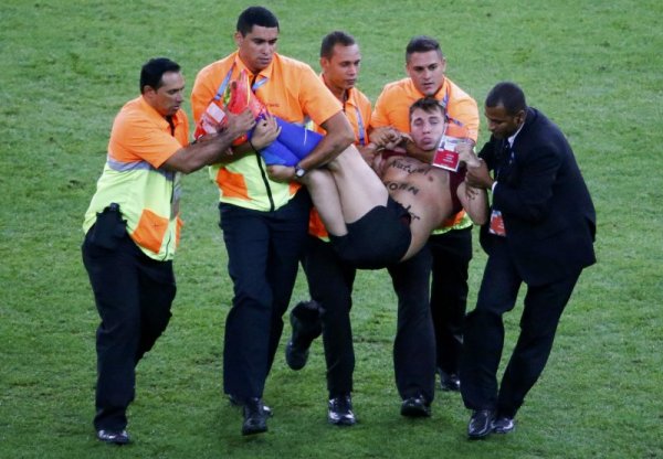 Стюарди изнасят фен, който нахлу по време на финала на Световното първенство по футбол между Германия и Аржентина. Снимка: Reuters