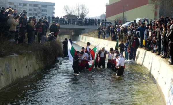 Дванайсет души нагазиха в студените води на река Новоселска в Сливен, за да изиграят мъжко хоро на Йордановден. Празникът започна с водосвет, отслужен от отец Силвестър от храма &quot;Света София&quot;, който хвърли и богоявленския кръст. Снимка: БТА