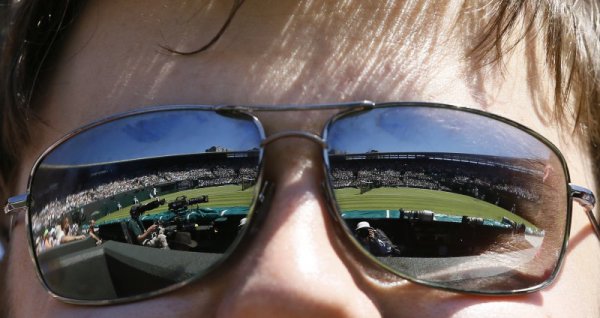 Корт №1 на Уимбълдън се отразява в очилата на зрител по време на откритото първенство на Великобритания по тенис. Снимка: БТА
