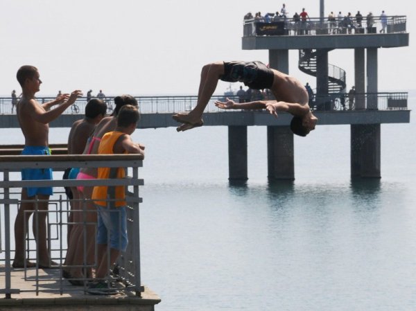Бургаски тинейджъри правят атрактивни скокове в морето от моста на стария плаж. Снимка: Булфото