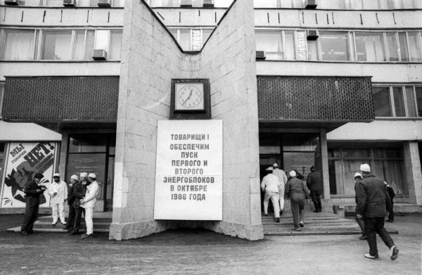 Работници влизат в АЕЦ Чернобил седмици след аварията. На табелката се чете обещание първи и втори блок на централата да бъдат пуснати отново в експлоатация през октомври 1986 г.  Снимка: Reuters