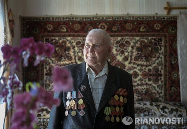 Фьодор Ефимович Маригин. Роден е на 17 декември 1927 г. в село Кесова Гора Тверска обалст. Призован е в армията на 16 години прем ноември 1944 г. В състава на войските на НКВД е бил на Прибалтийския фронт. Воюва срещу &bdquo;Горските братя&ldquo; - литовско националноосвободително движение, обявяващо се против съветската власт, за независимост. От 1947 г. е на военна служба в Москва, участвал е в 4 парада. Демобилизиран е през 1951 г. През 1955 г. се връща в родния си край и работи в комуналното стопанство.
Снимка: РИА Новости
