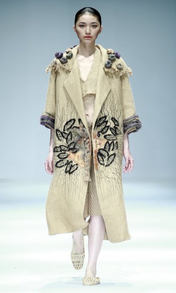 Манекенка представя тоалет на местен дизайнер по време на модно ревю в Пекин. Снимка: БТА