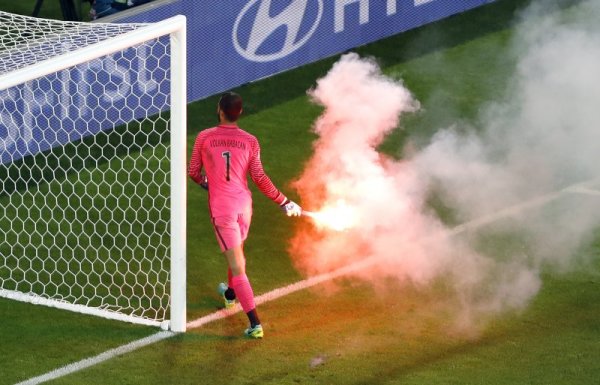 Вратарят на Турция Волкан Бабаджан премахва от терена паднала факла от феновете по време на мача между Турция и Чехия от Евро 2016. Турците победиха с 2:0 и чакаш днешните мачове за да разберат, дали продължават напред в турнира. Снимка: БТА