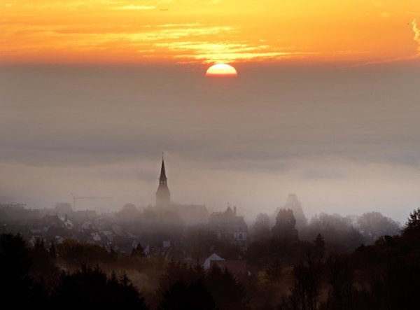 Слънцето изгрява сред есенната мъгла в германския град Кронберг. Снимка: БТА