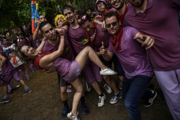 Млади хора се забавляват по време на винена битка в испанското село Харо. Стотици туристи присъстват за поредна година на странния фестивал, в който хората изливат един върху друг хиляди литри червено вино. Снимка: БТА