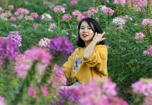 Туристка се снима сред красиви цветя в парк в китайската провинция Фудзиен. Снимка: БТА