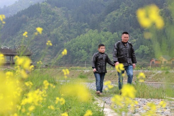 Баща води сина си към училище в село в китайската провинция Гуанджоу. Снимка: БТА