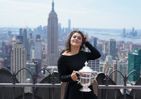 Шампионката от US Open Бианка Андрееску позира с трофея от надпреварата на един от небостъргачите в Ню Йорк. Снимка: БТА