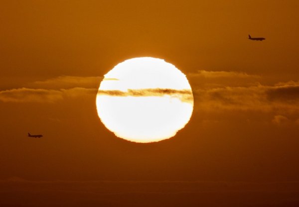 Два самолета преминават на фона на изгряващото слънце над Франкфурт, Германия. Снимка: БТА
&nbsp;