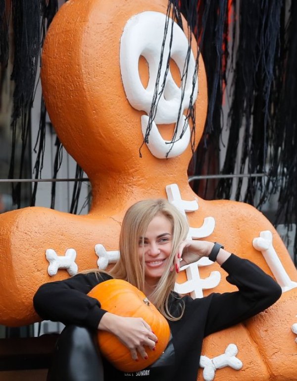 Украинка се снима с тиква в центъра на Киев по повод Хелуин. Празникът, който е част от западната култура, добива все по-голяма популярност в Украйна. Снимка: БГНЕС